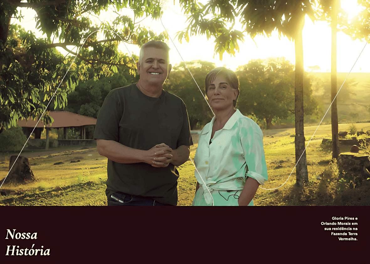 Two people outdoors in a sunny landscape with trees and a rustic building.