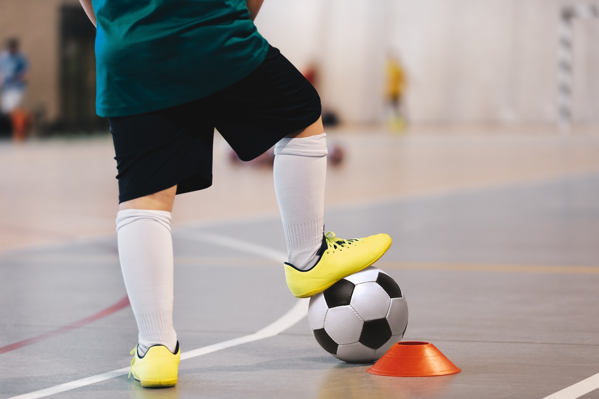 Jogador de Futsal treinamento com bolas. Pavilhão desportivo de futebol indoor. Jogador de futsal do futebol, bola, andar de futsal. Currículo desportivo. Liga de Futsal. Jogadores de futebol indoor com bola de futebol clássico.