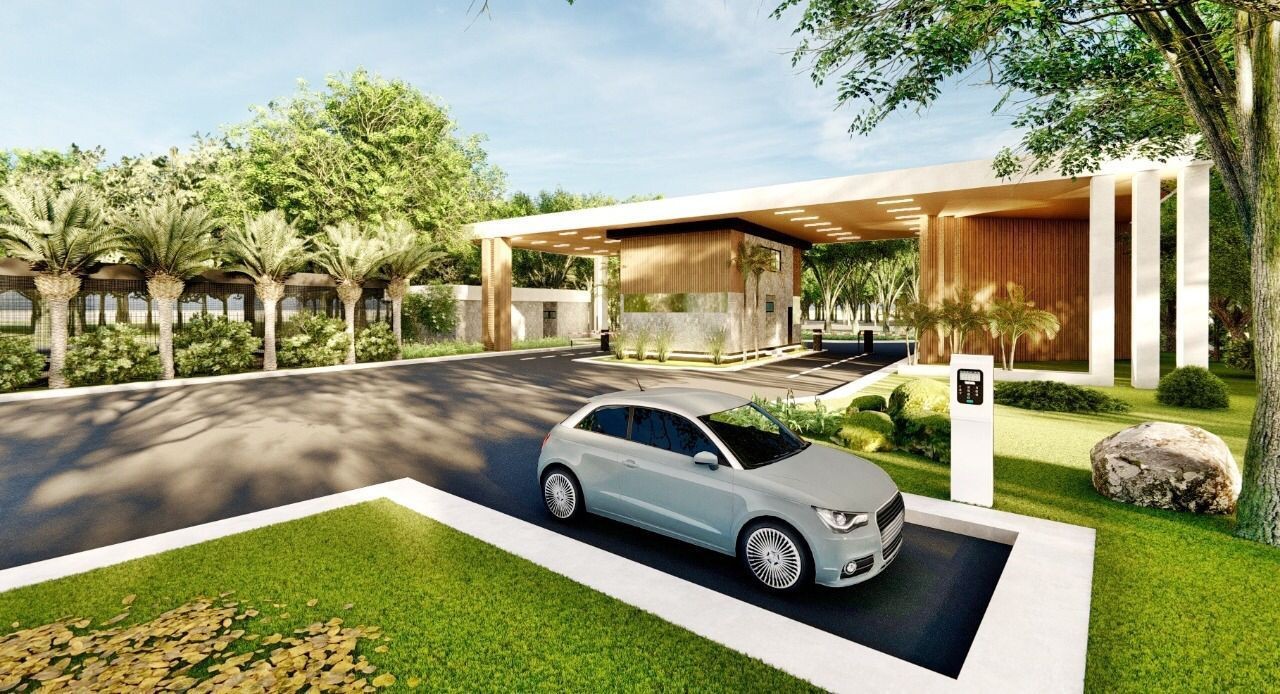 Modern residential gate with a sleek car entering, surrounded by lush greenery and well-maintained landscaping.